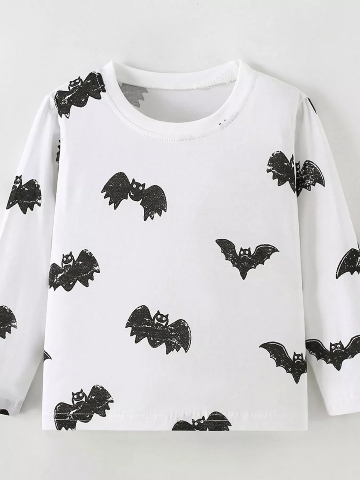 Front product view of the white children's black-bat-print top.