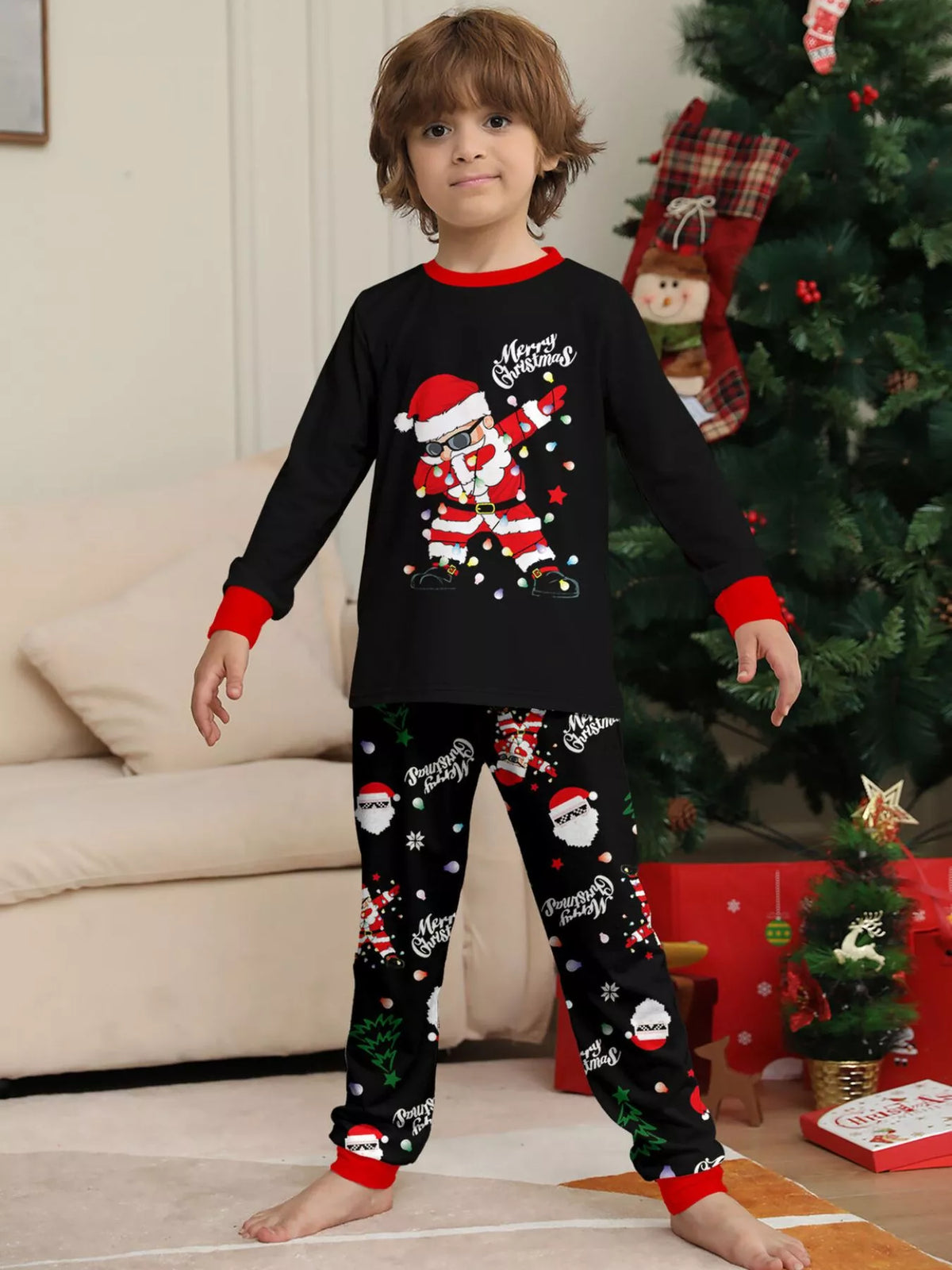 Child modeling the black Santa graphic Christmas pajama set.