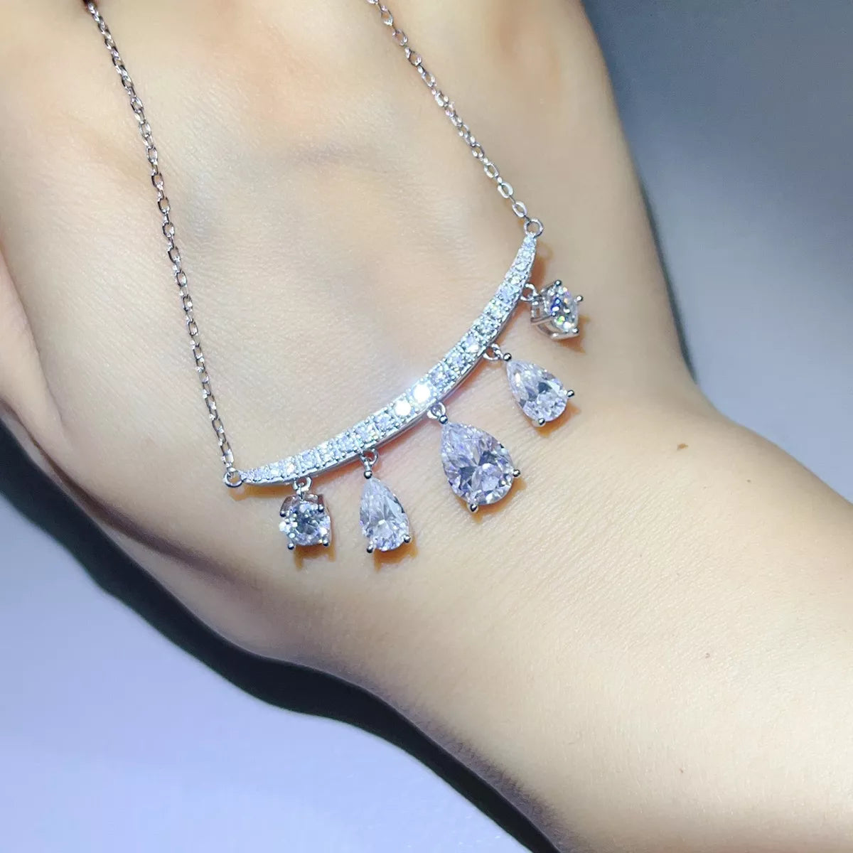 Silver-tone necklace with graduated teardrop stone pendants — detail view
