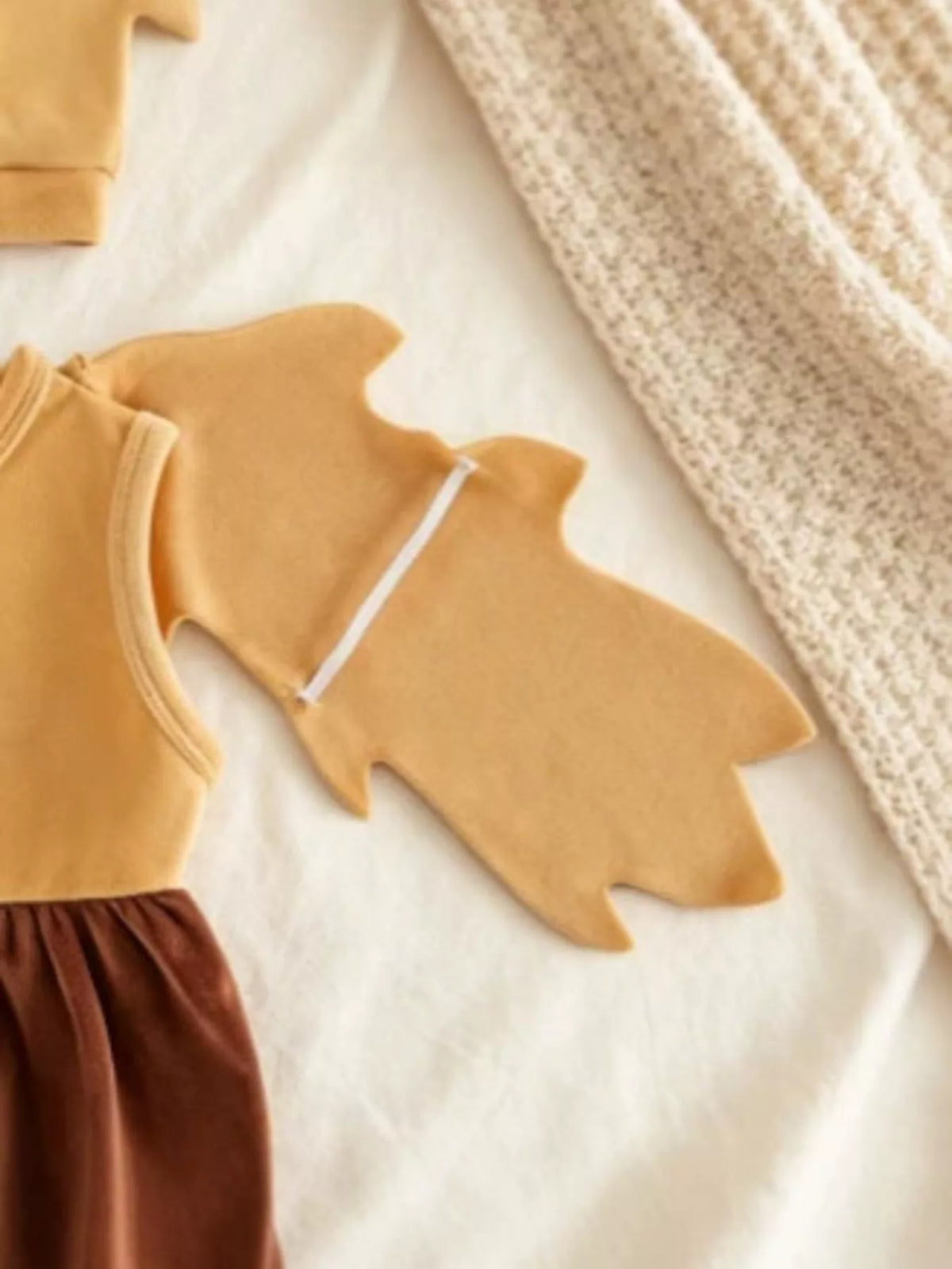 Mustard owl-wing sleeve detail beside the brown bottoms