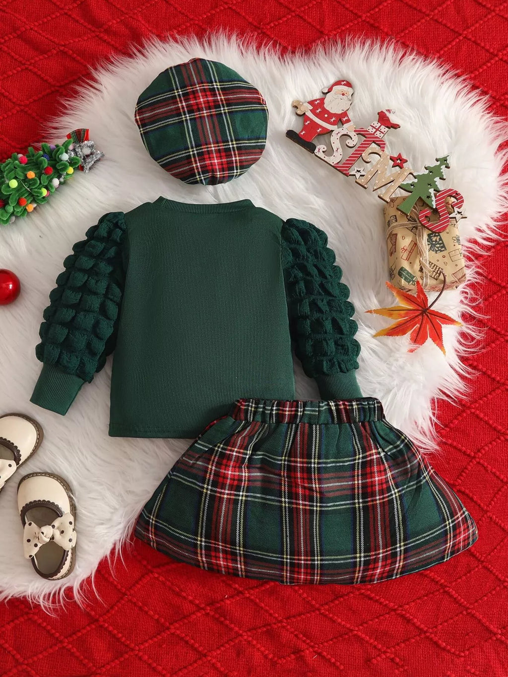 Back flat lay of the green top, green plaid skirt and matching beret.