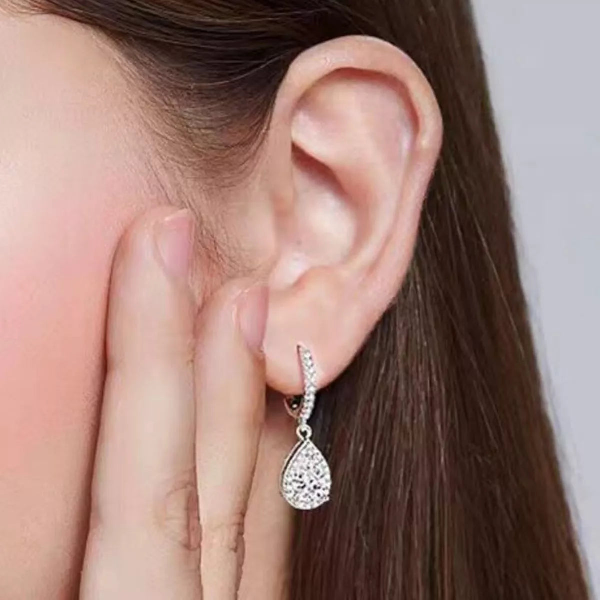 Silver-tone hoop earrings with teardrop halo stone drops — detail view