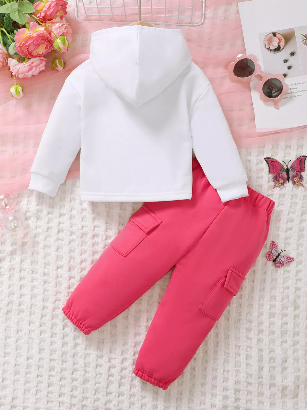 Children’s white graphic hoodie and pink cargo pants displayed flat