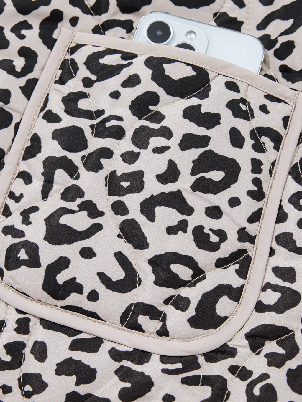 Close-up of a leopard-print patch pocket with contrast trim.