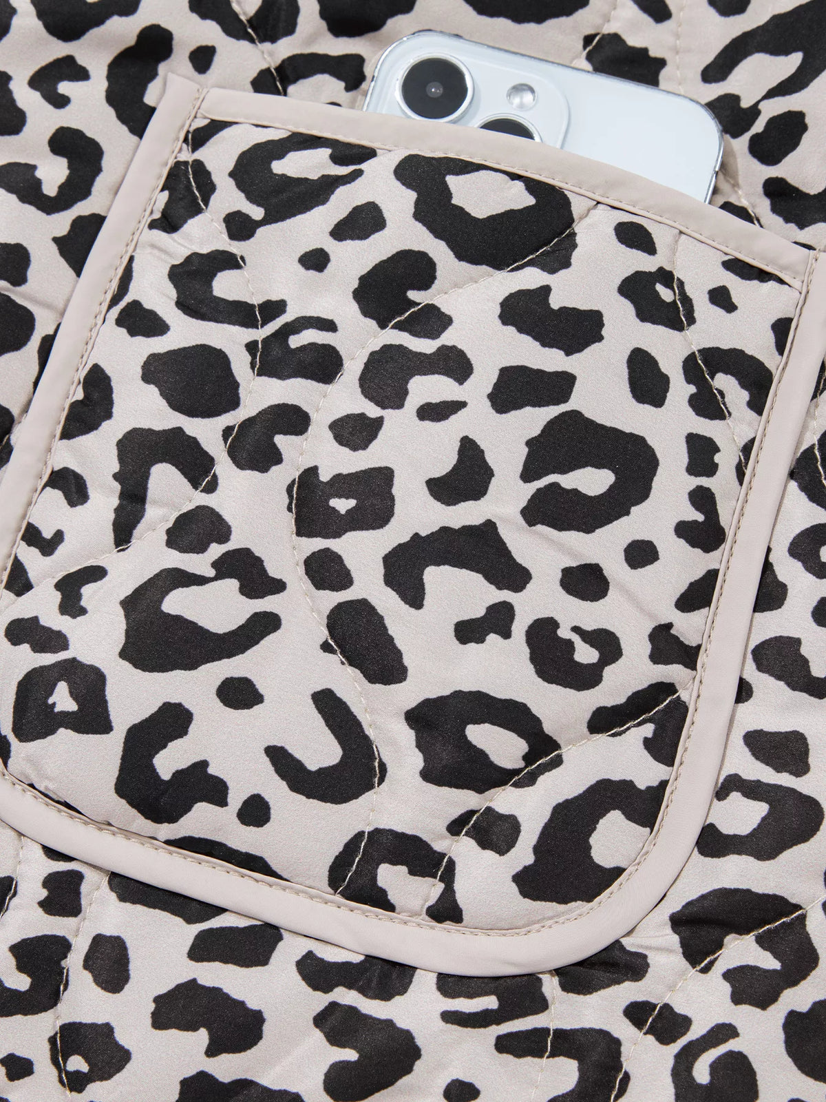 Close-up of a leopard-print patch pocket with contrast trim.