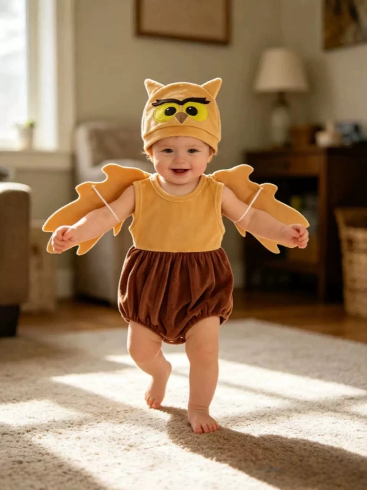 Children’s mustard owl-wing top, brown bottoms and owl hat worn by a child