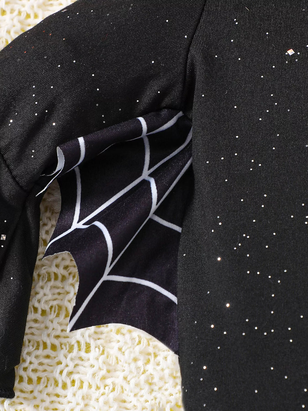 Spiderweb print on a black bodysuit sleeve