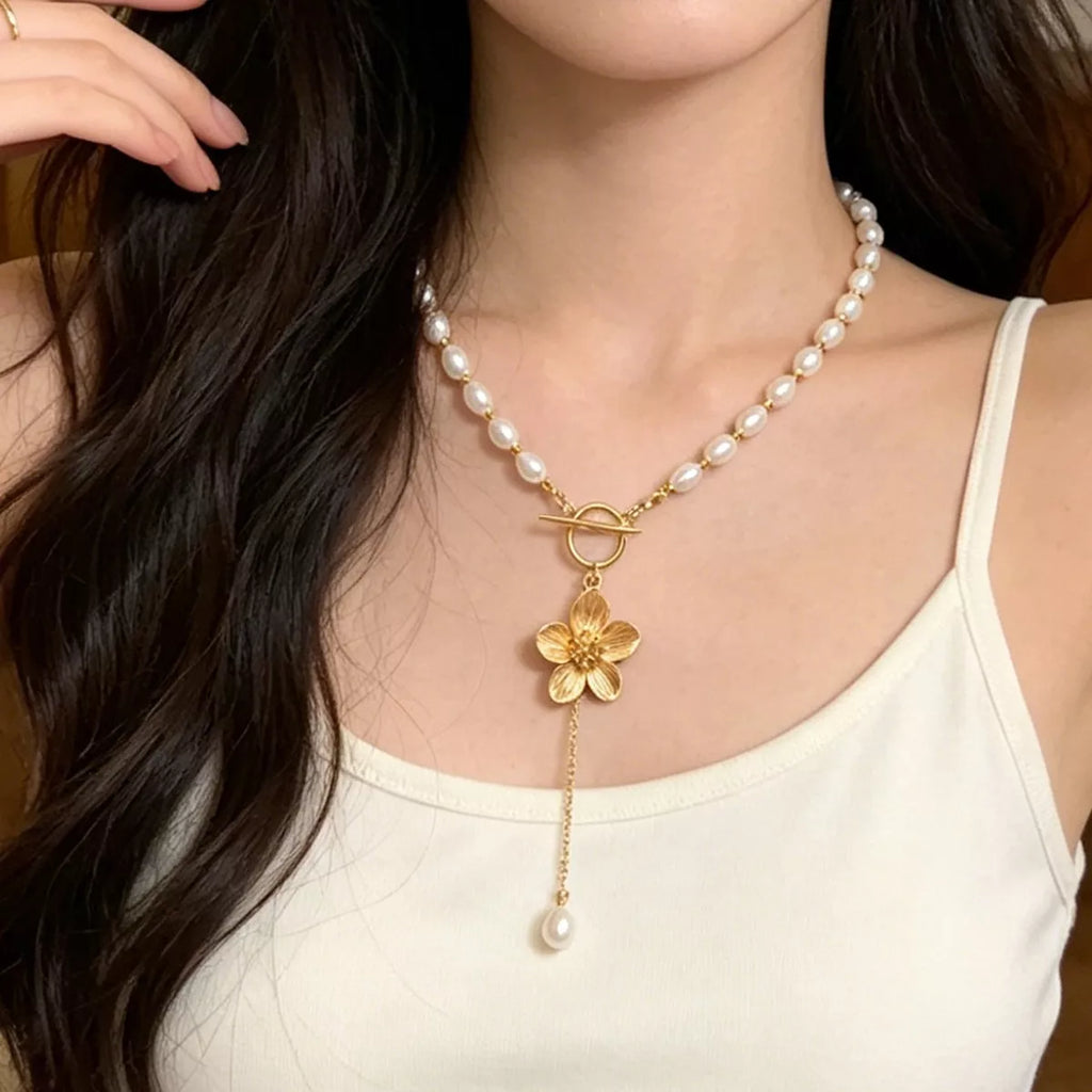 Pearl-like bead choker with gold-tone flower clasp and long pendant