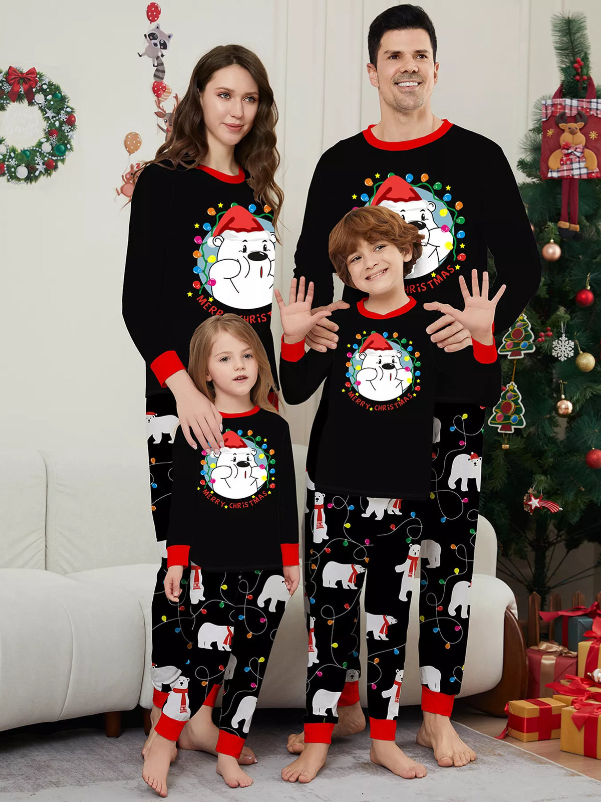 Family wearing black Christmas graphic tops and black polar-bear-print pajama pants.