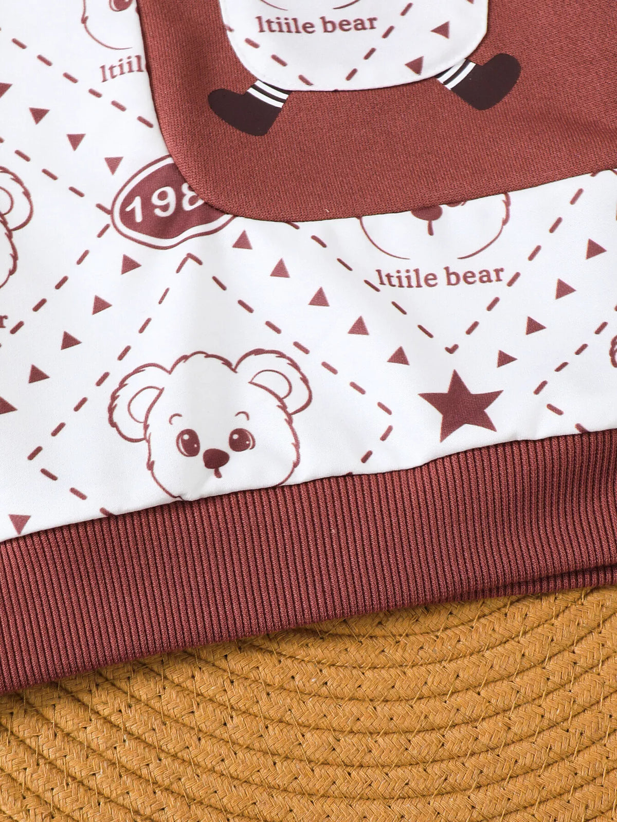 Little bear graphics and maroon sweatshirt hem detail