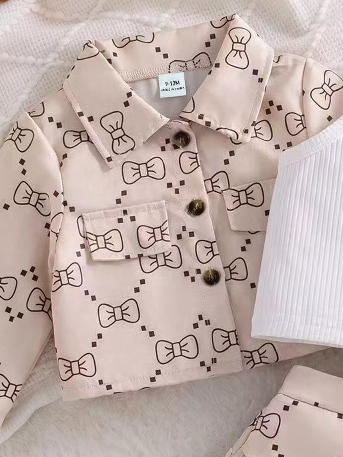 Bow pattern and button-front detail on the children’s jacket