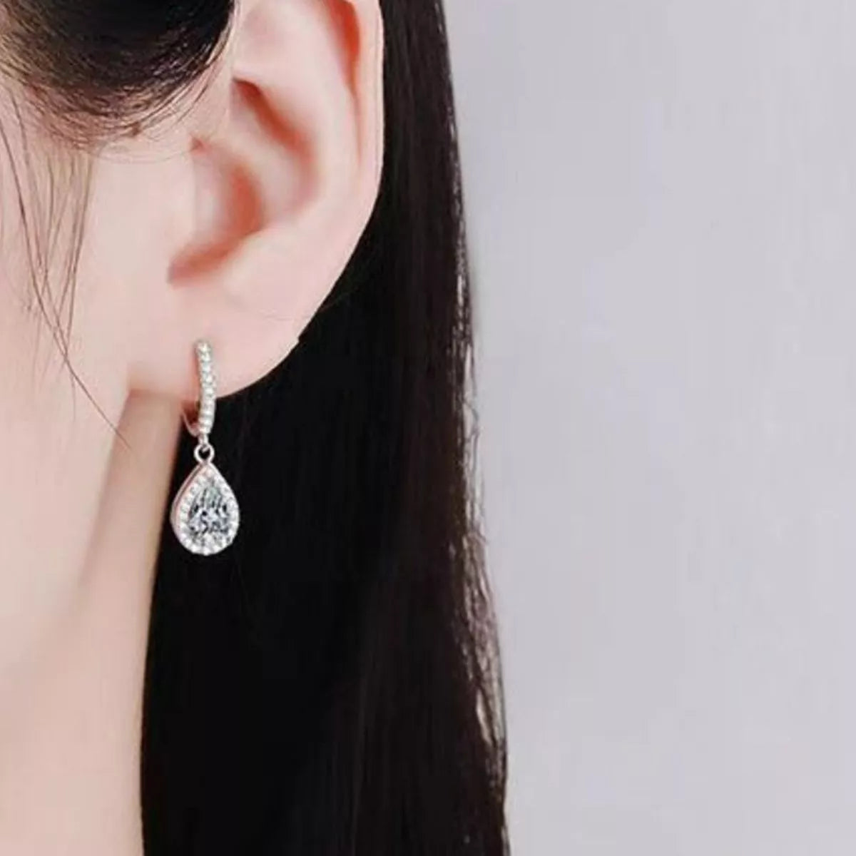 Silver-tone hoop earrings with teardrop halo stone drops — detail view