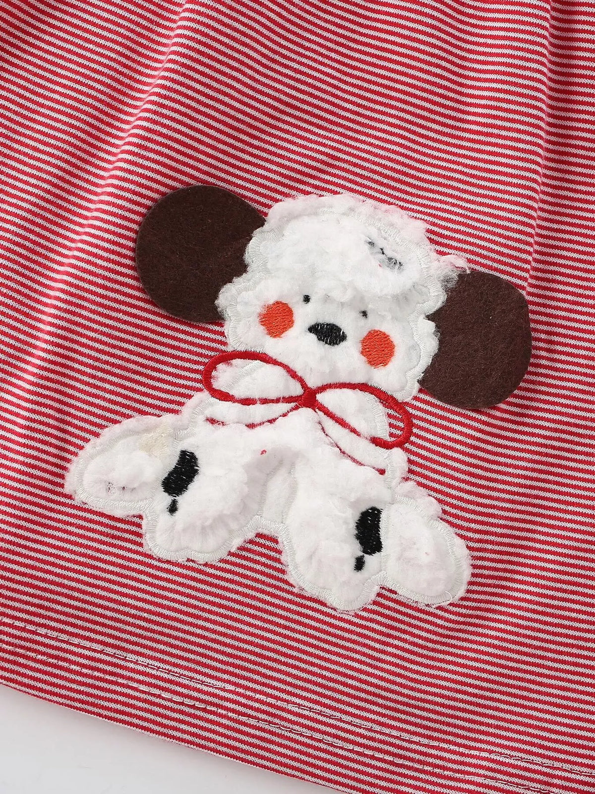 Close-up of the textured white puppy applique with brown ears and red bow.