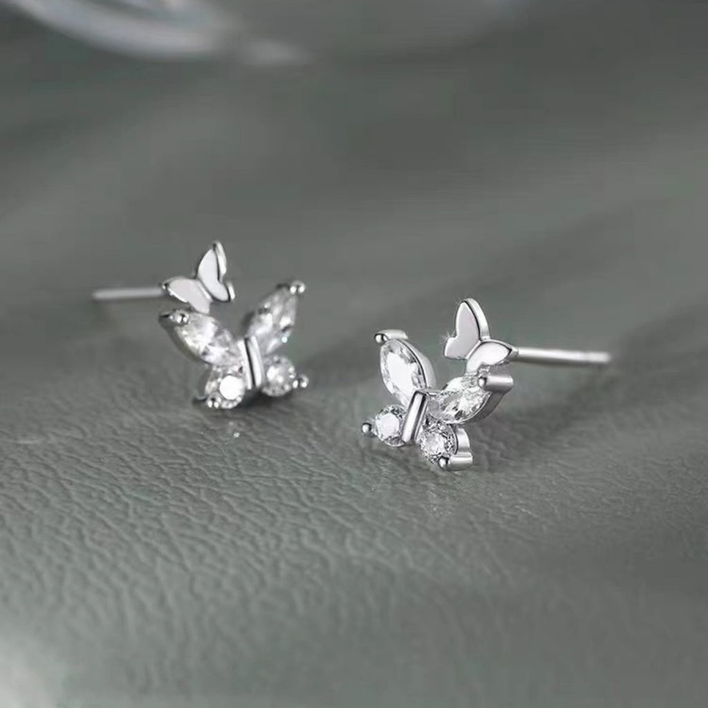 Silver-tone butterfly stud earrings with clear stones — detail view