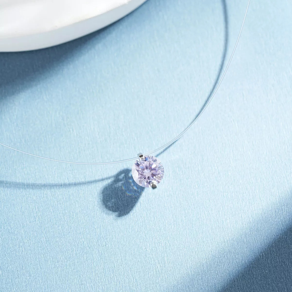 Silver-tone necklace with a round colored stone pendant — detail view