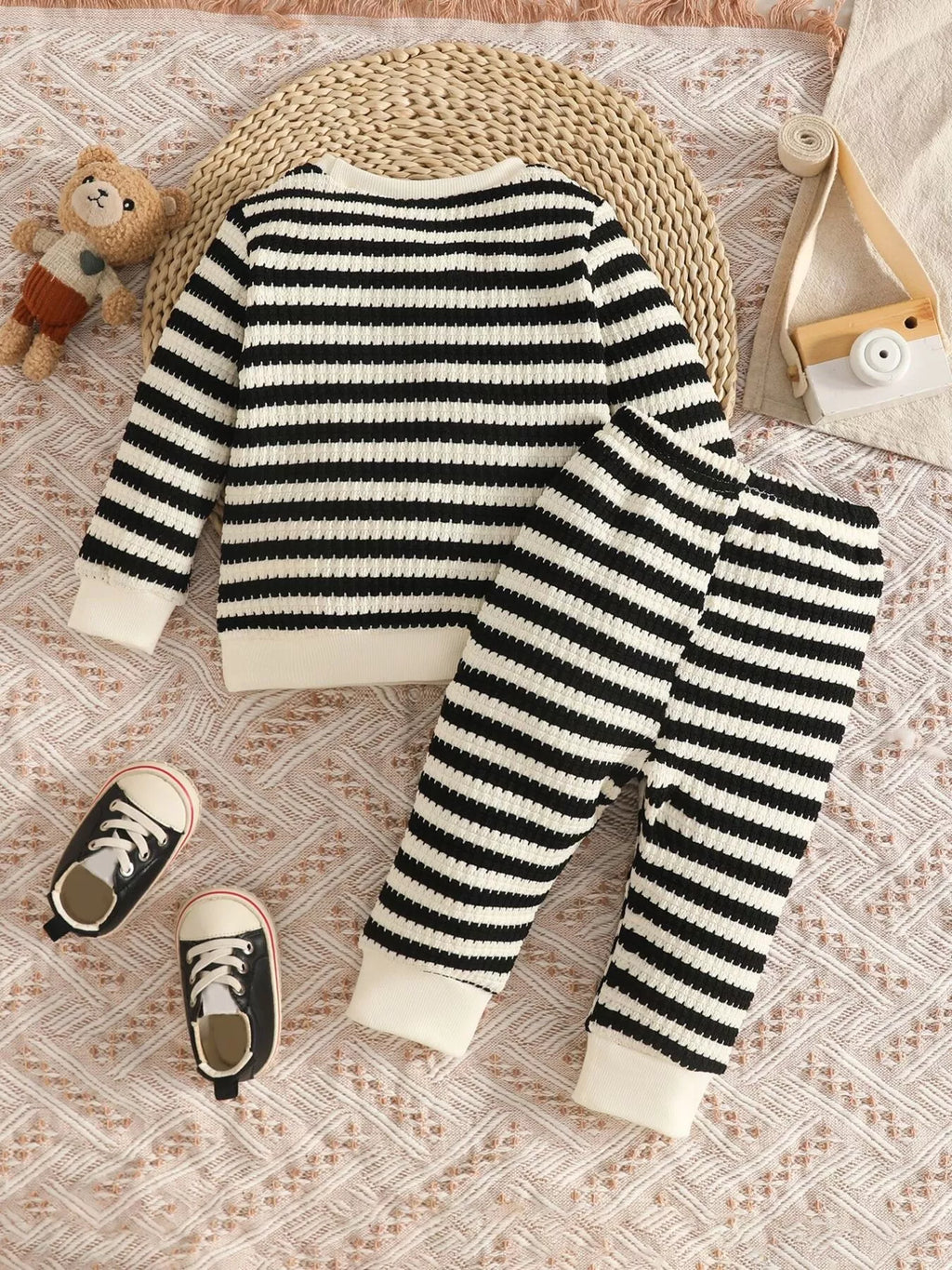 Black and cream striped knit top and matching pants displayed flat