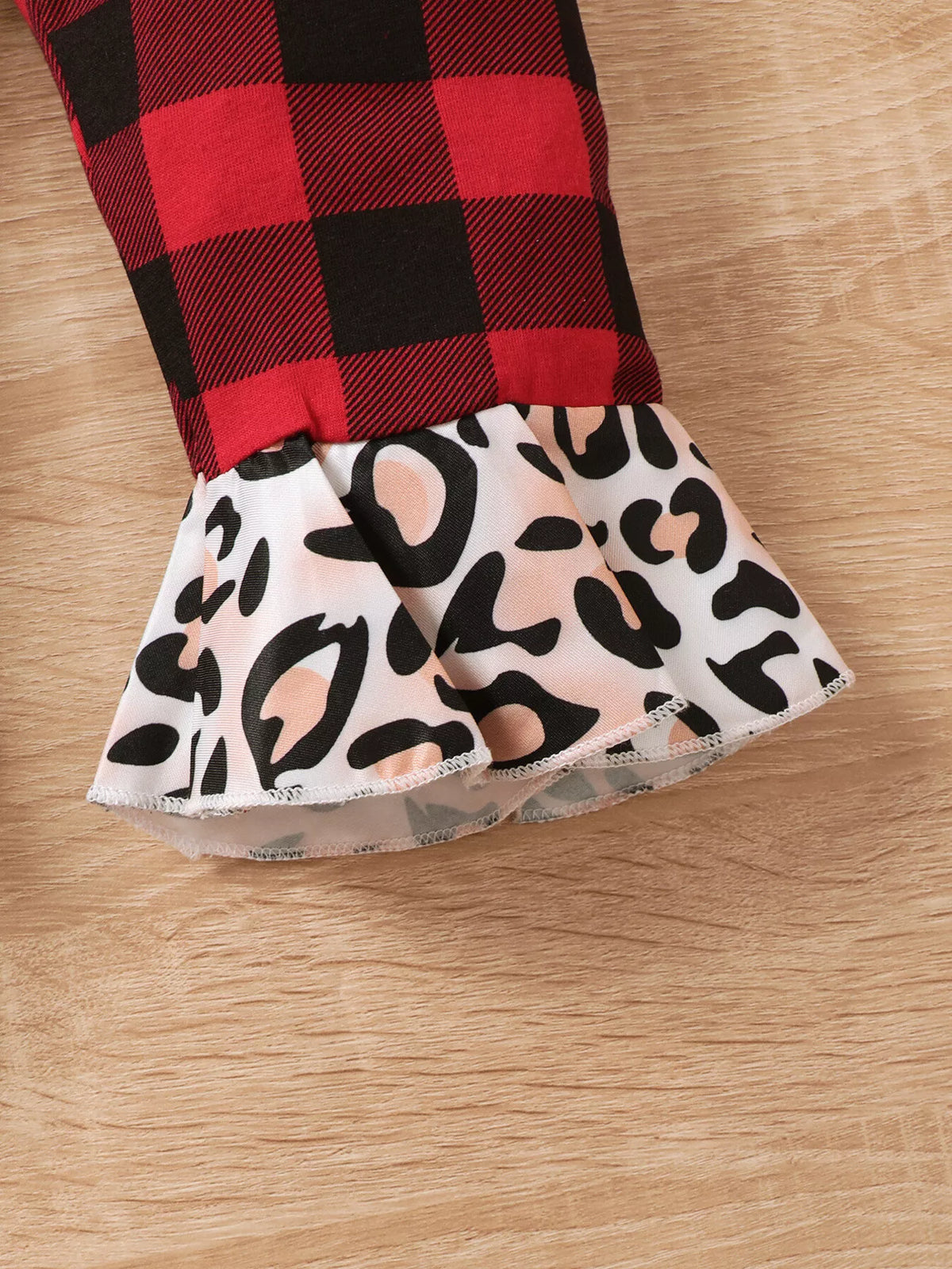 Close-up of the plaid pant leg with contrasting leopard-print ruffle cuff.