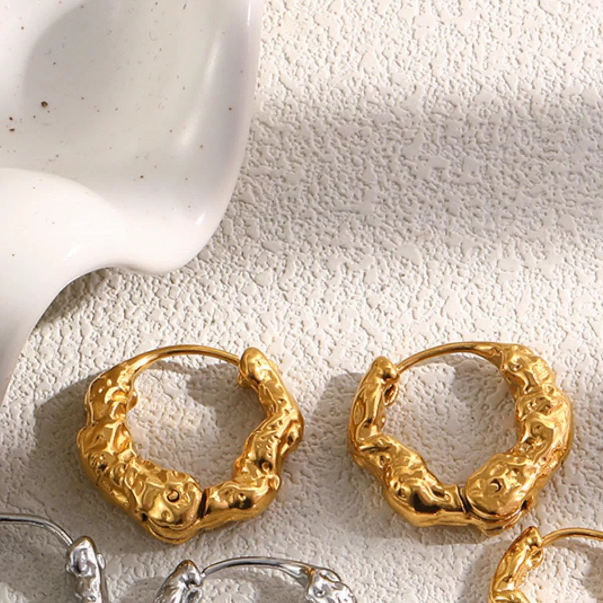 Textured gold-tone hoop earrings — detail view