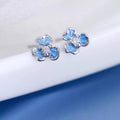 Silver-tone flower stud earrings with blue stones — detail view