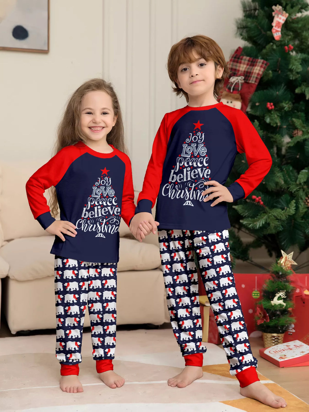Navy and red Christmas graphic pajama top with matching festive-print pants worn by two children