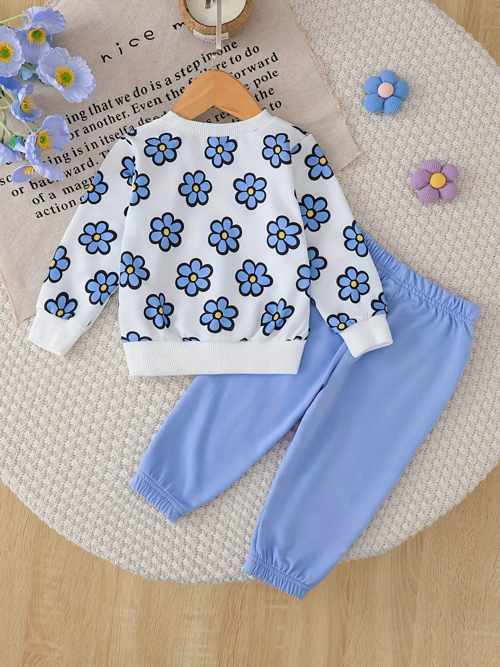 Back flat lay of the white blue-flower sweatshirt and light blue pants.