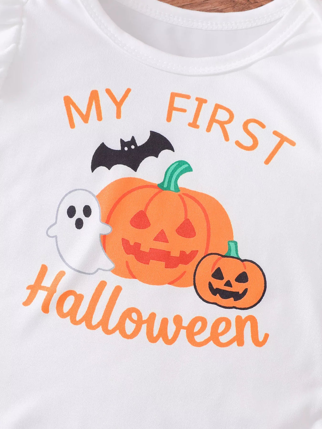 Close-up of My First Halloween lettering with pumpkin, ghost and bat graphics.