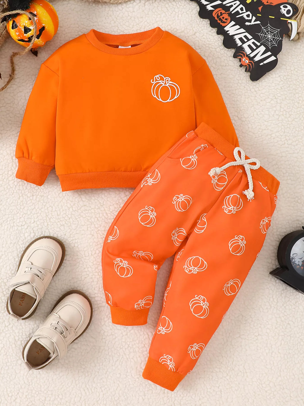Orange pumpkin-print sweatshirt and matching drawstring pants displayed flat