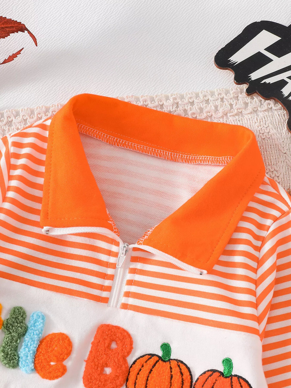 Close-up of the orange collar and zipper on the orange striped top.