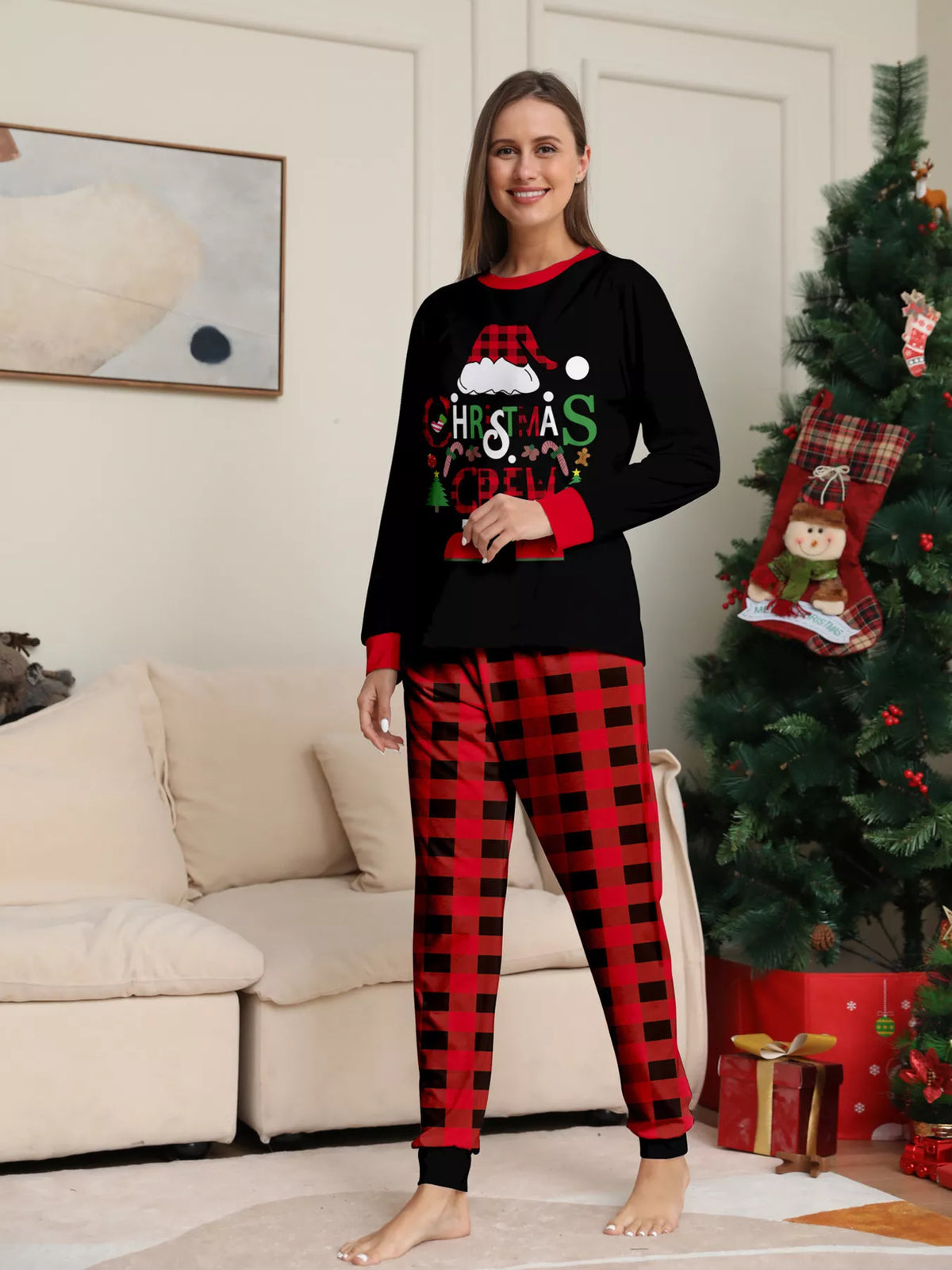 Woman modeling the black Christmas graphic pajama top and red plaid pants.