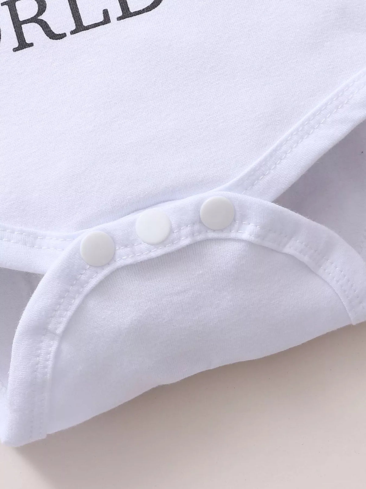 Snap fasteners on the white baby bodysuit