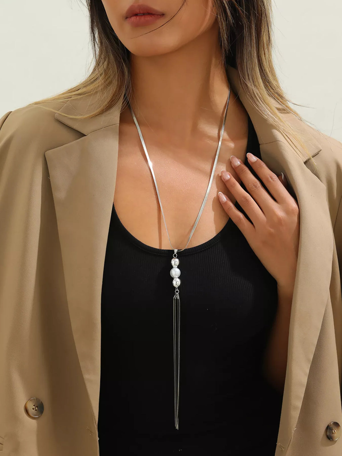Long silver-tone necklace with bead accents and chain tassel