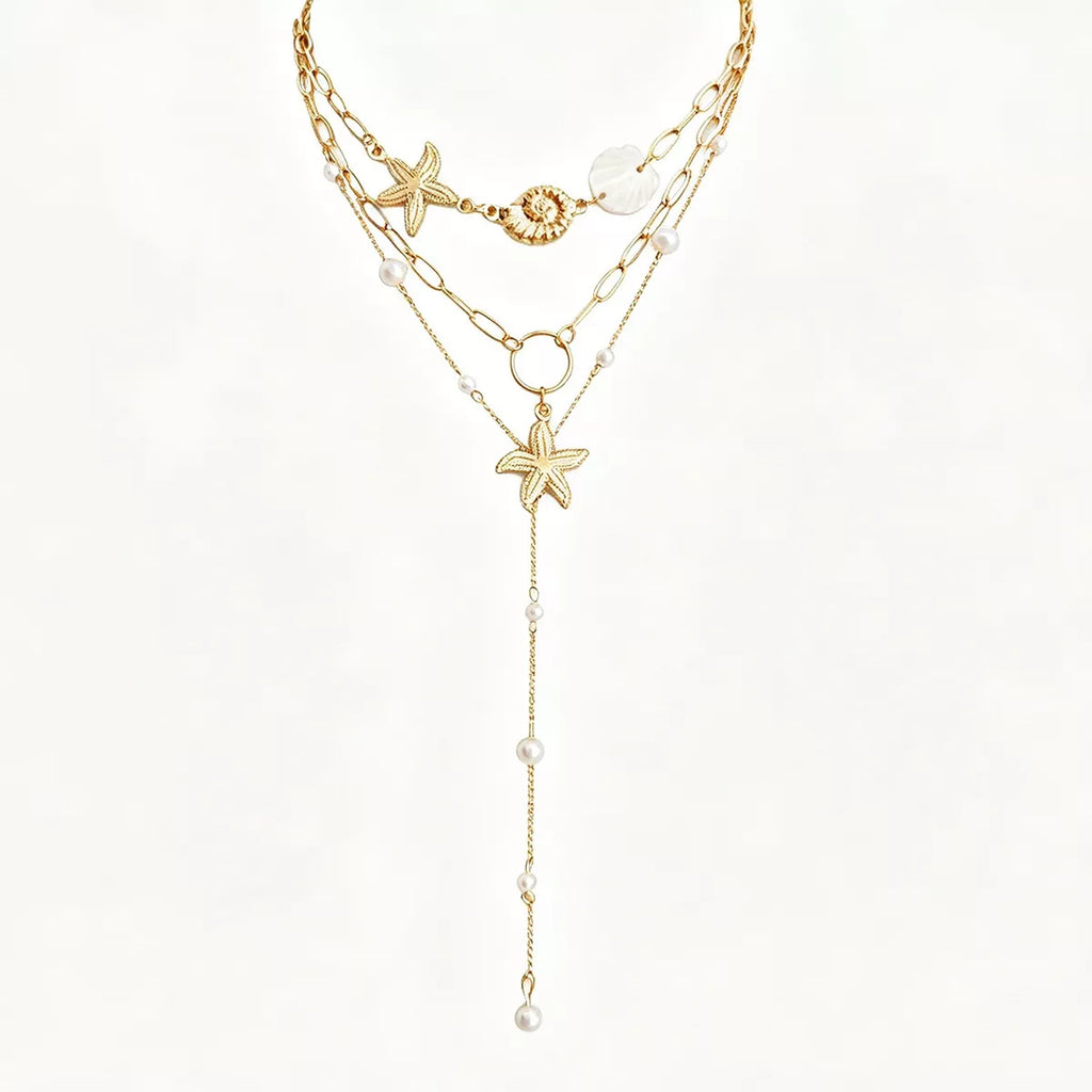 Layered gold-tone necklaces with starfish and shell charms