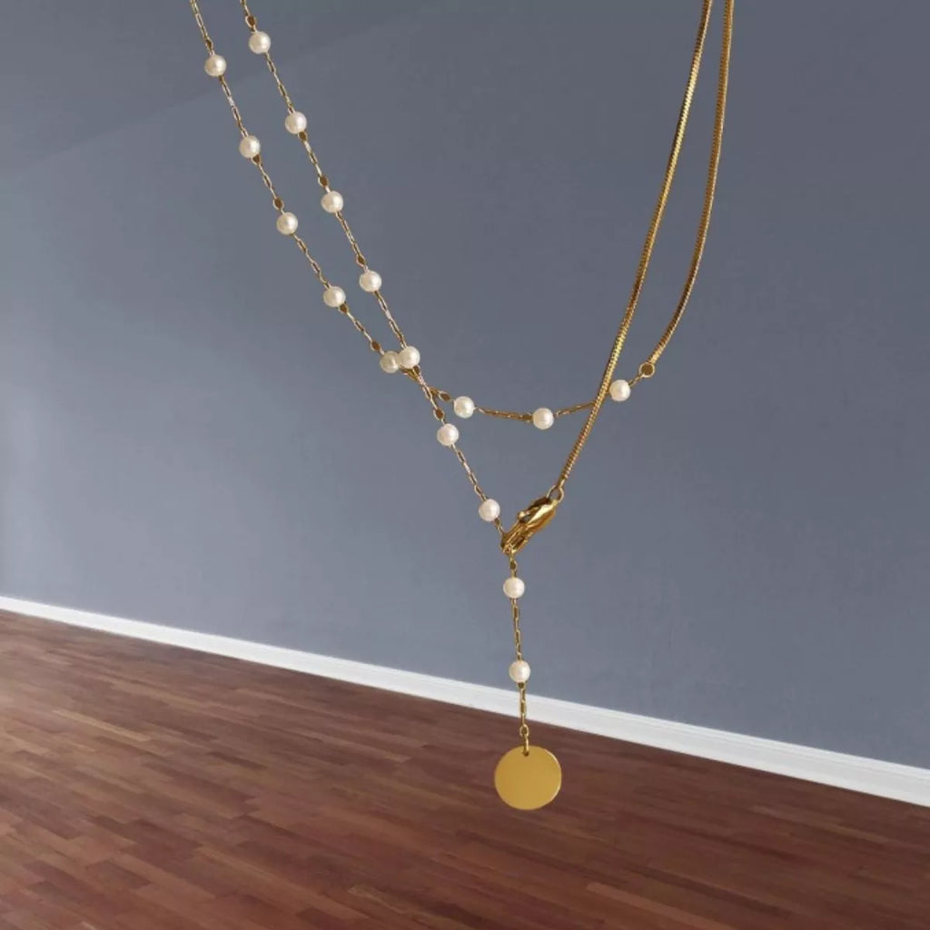 Gold-tone pearl-like station necklace with coin pendant — detail view