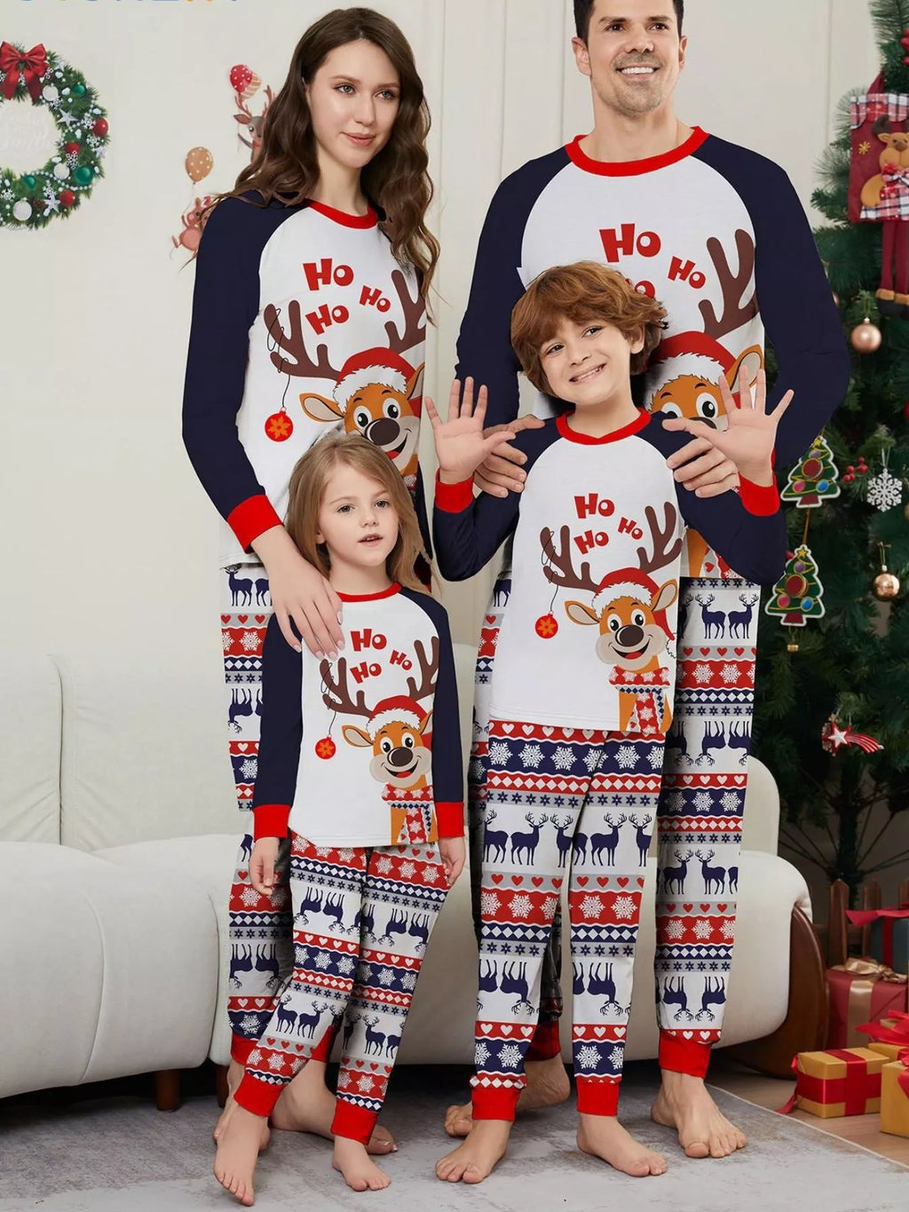 Family wearing white Christmas tops with navy sleeves and festive striped pajama pants.