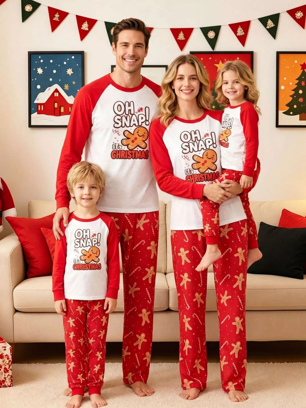 Family wearing matching white Oh Snap gingerbread graphic tops with red sleeves and red printed pajama pants.