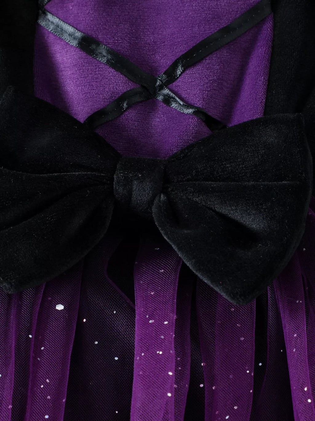 Close-up of the dress's crisscross bodice ribbons and black waist bow.