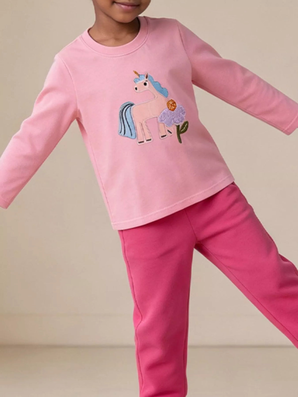 Long-sleeve children’s top with colorful embroidered graphics worn by a child