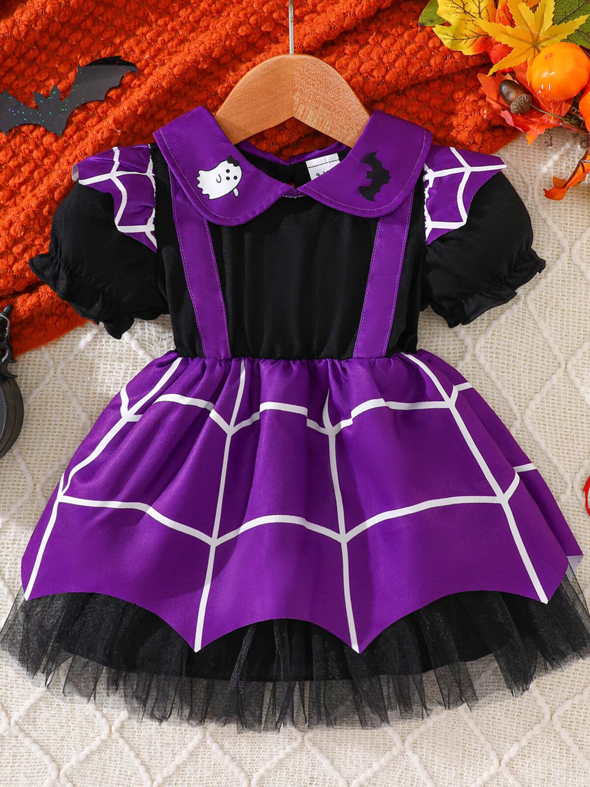 Flat lay of the purple spiderweb skirt dress with black puff sleeves and tulle trim.