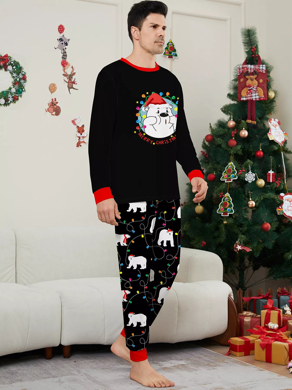 Man modeling a black Christmas graphic top and black polar-bear-print pajama pants.