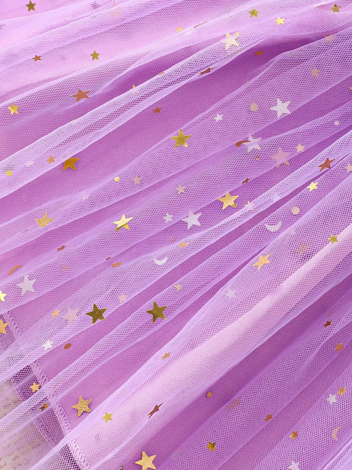 Close-up of gold stars scattered across purple tulle skirt layers.