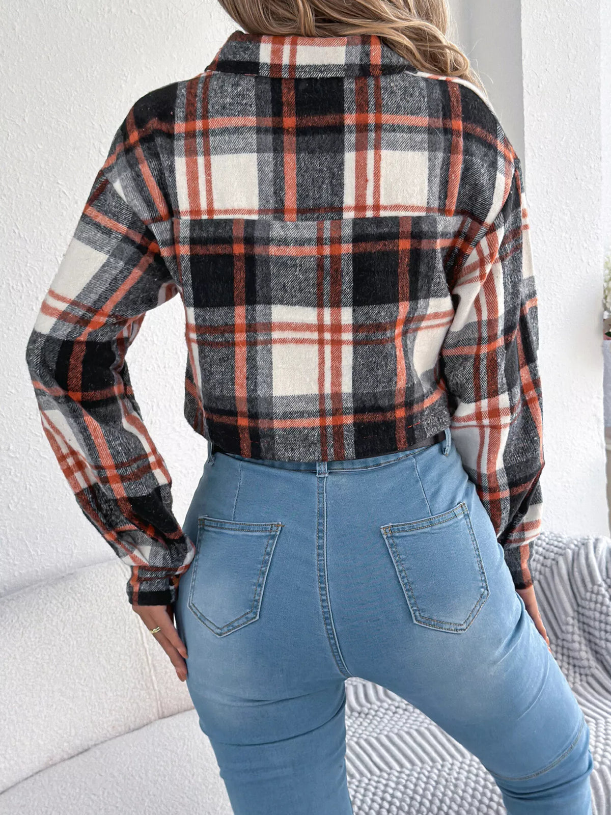 Back view of the black, white and rust plaid cropped jacket.