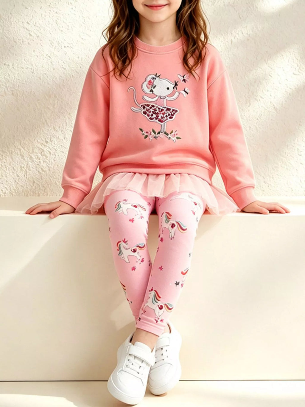 Coral embroidered sweatshirt with ruffle hem and pink printed leggings worn by a child