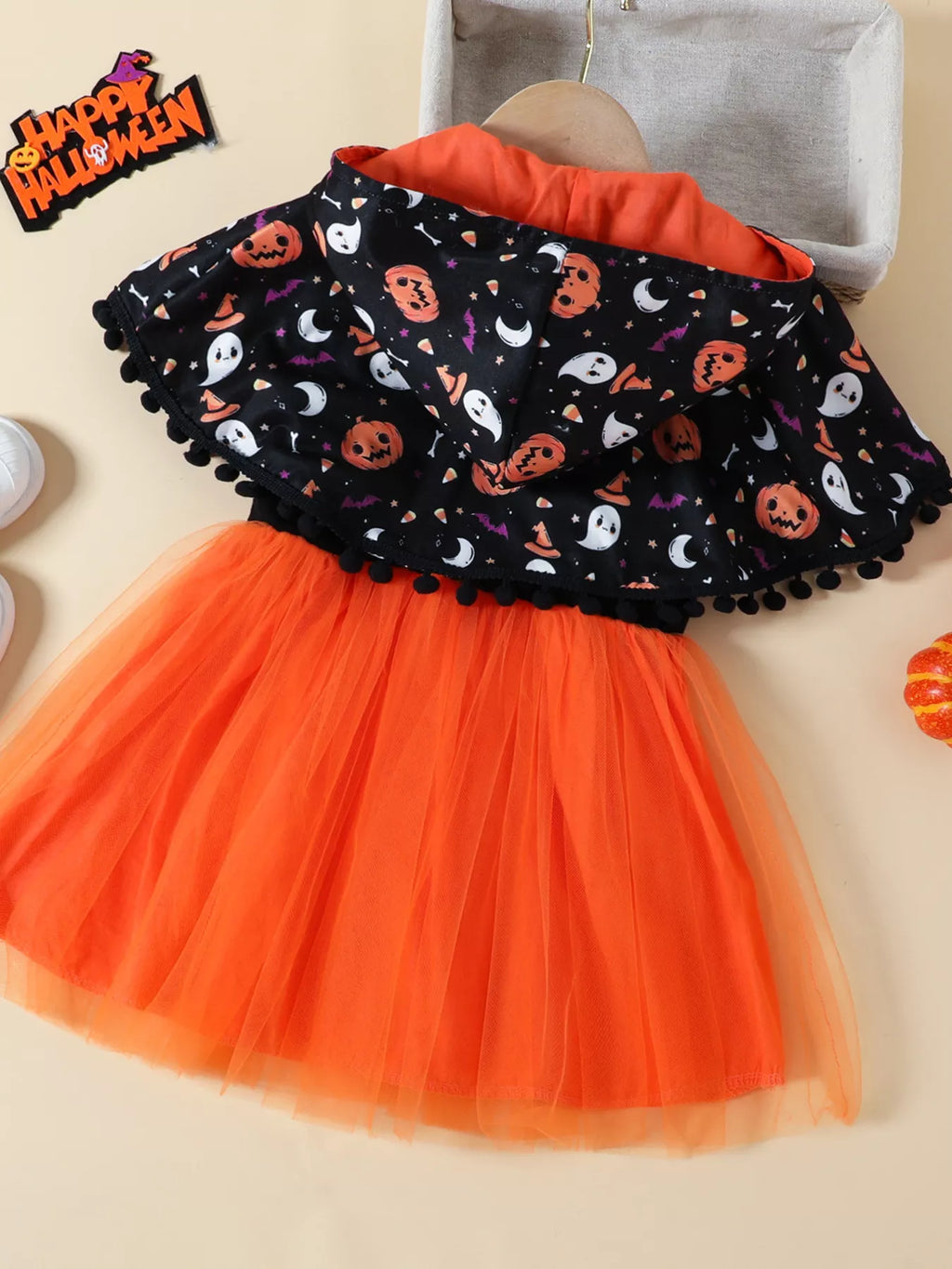 Back flat lay of the Halloween-print cape and orange tulle skirt.