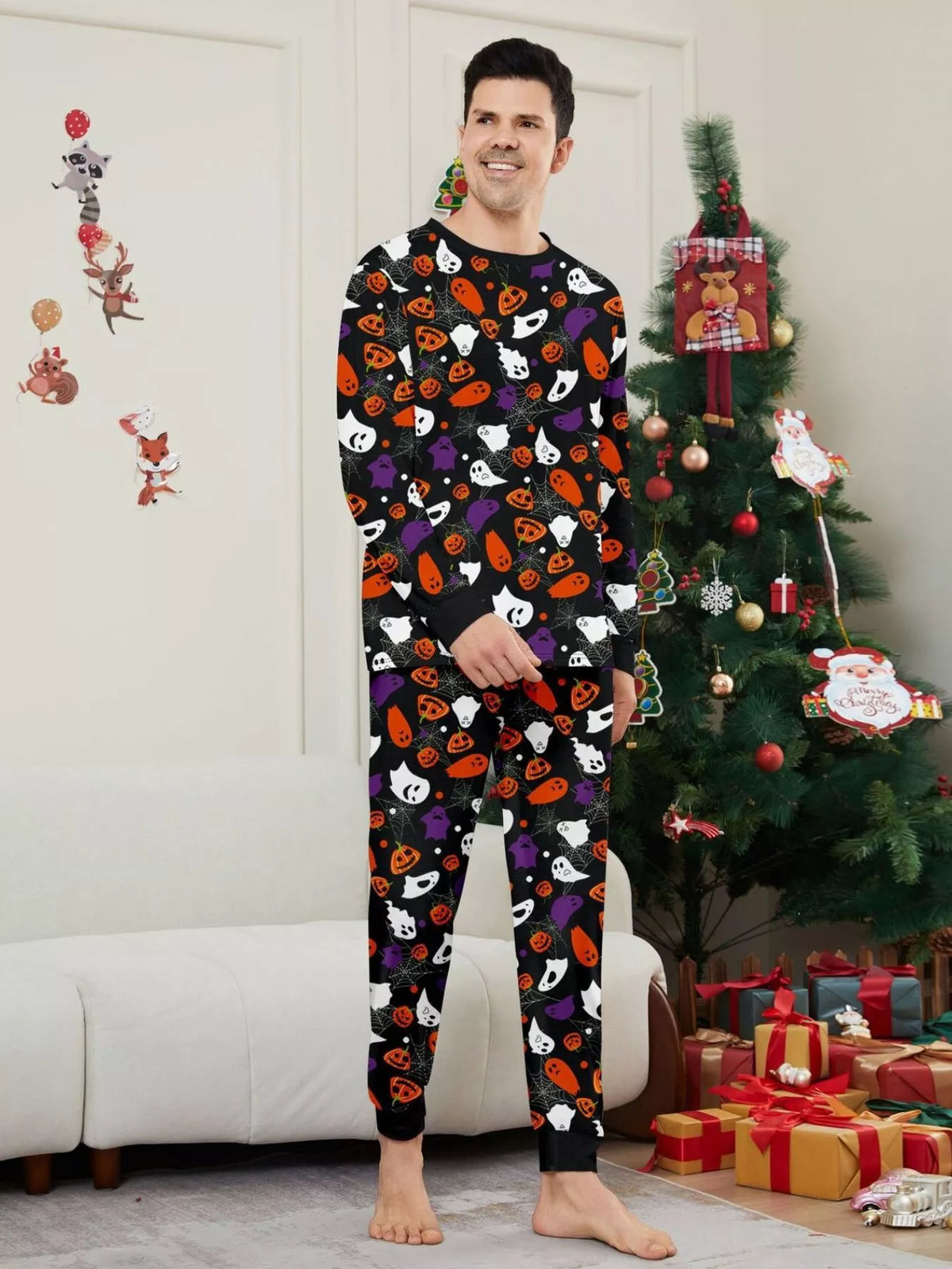 Black matching family pajamas with colorful Halloween ghost and pumpkin print worn by an adult