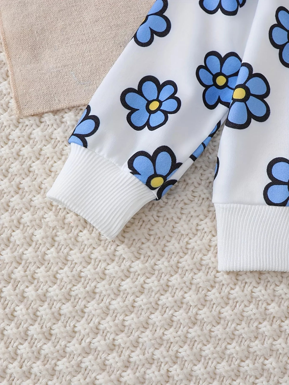 Close-up of the blue floral sweatshirt sleeve and cuff.