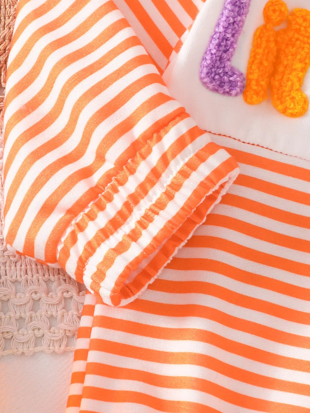 Close-up of the orange striped sleeve's ribbed cuff.