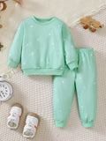 Mint green children's sweatshirt and jogger pants with small white star prints.