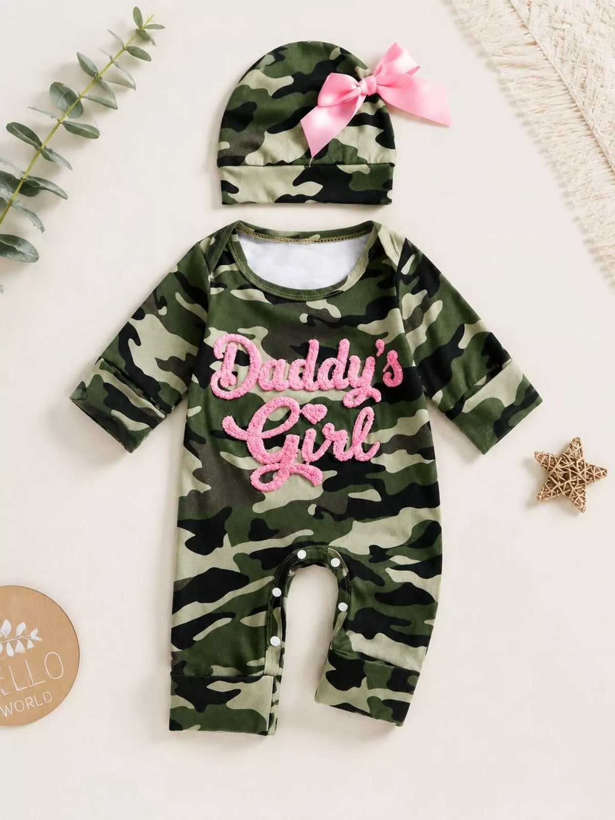 Children’s camouflage long-sleeve jumpsuit with pink Daddy’s Girl lettering and matching hat displayed flat