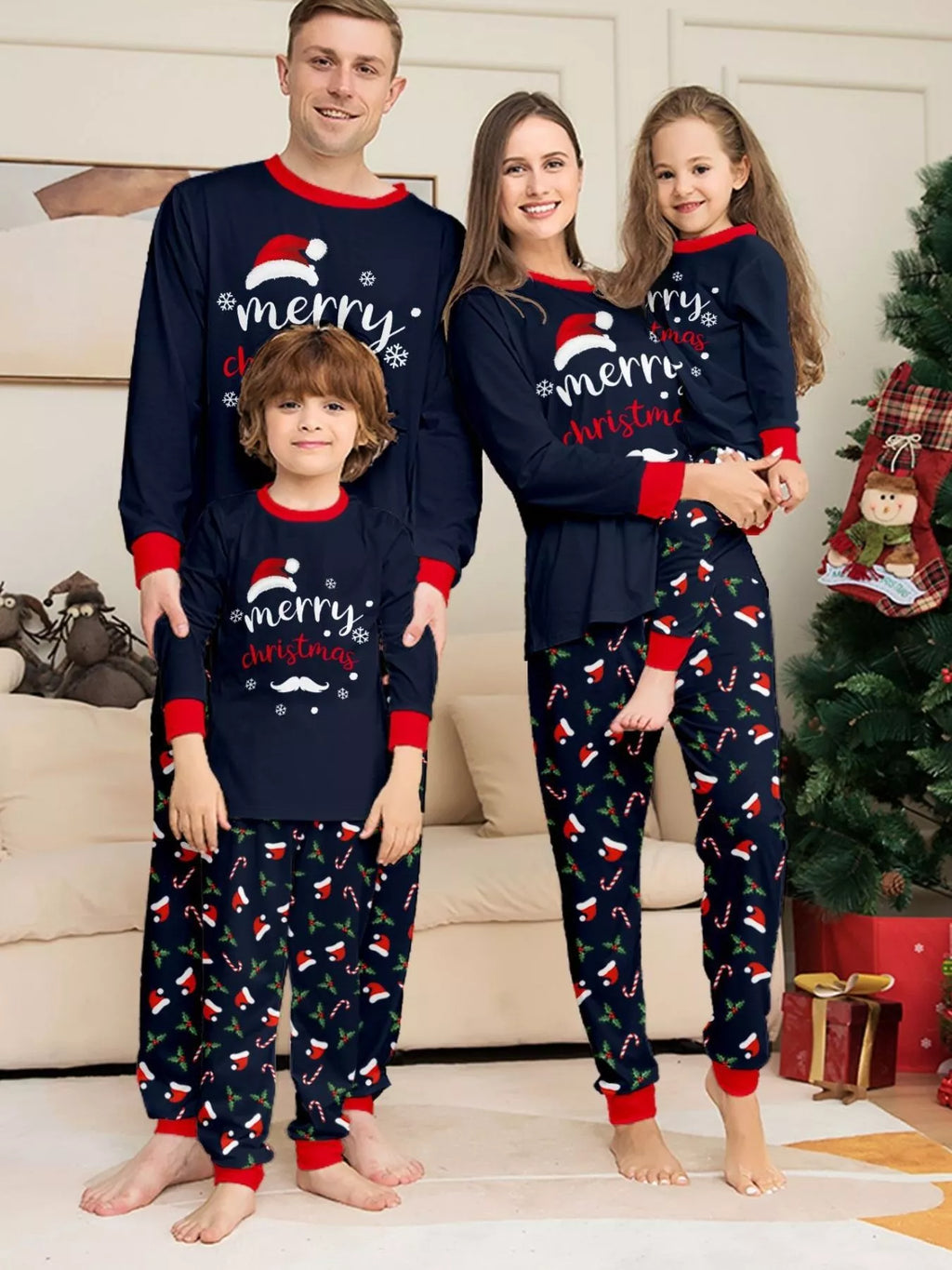 Family wearing matching navy Merry Christmas tops and festive printed pajama pants.