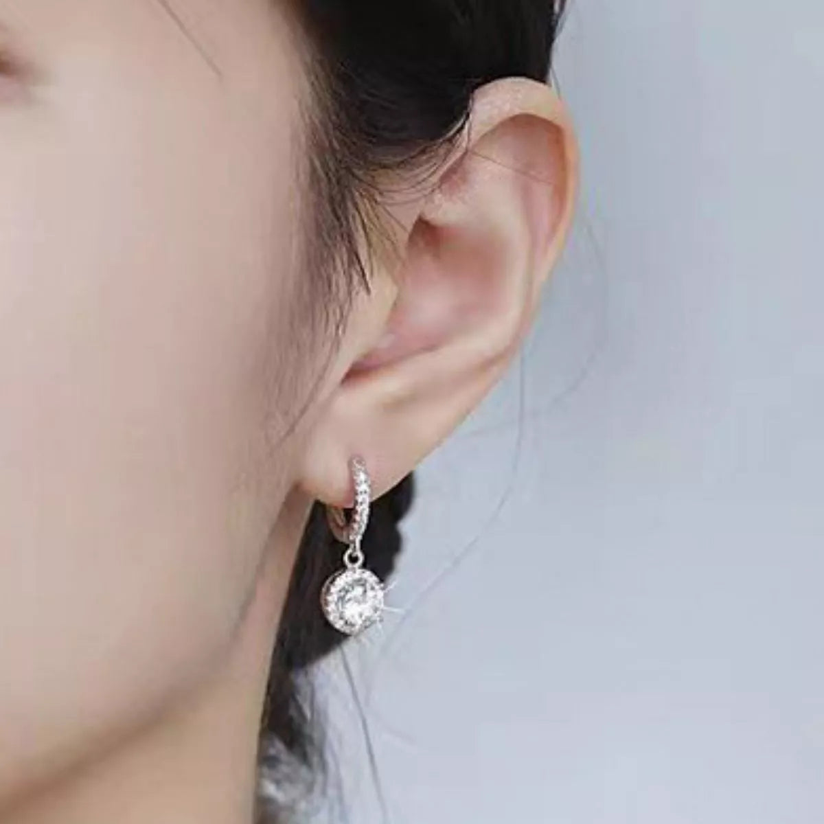 Silver-tone hoop earrings with round halo stone drops — detail view
